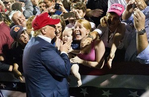 A woman with her baby shows excitement when the Republican presidential candidate Donald Trump greets them after he speaks at a campaign pep rally, Friday, Aug. 21, 2015, in Mobile, Ala. (AP Photo/Brynn Anderson)