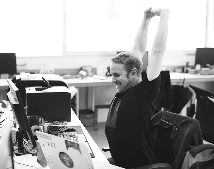 man stretching at his desk