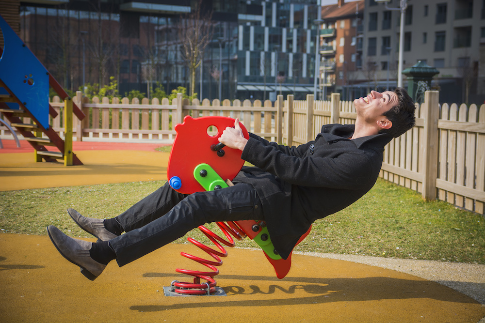 man on playground rocking horse